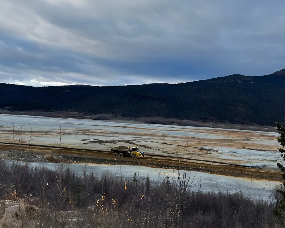Faro Mine – Construction of haul road over tailings pond to tailings pond cover panel.