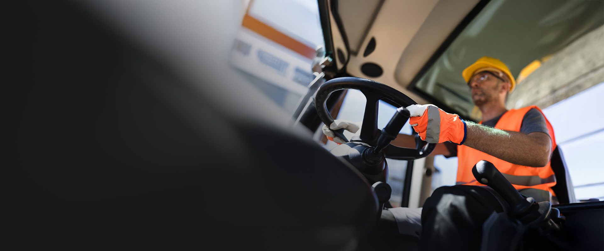 Equipment operator wearing a hard hat, gloves and high-visibility vest