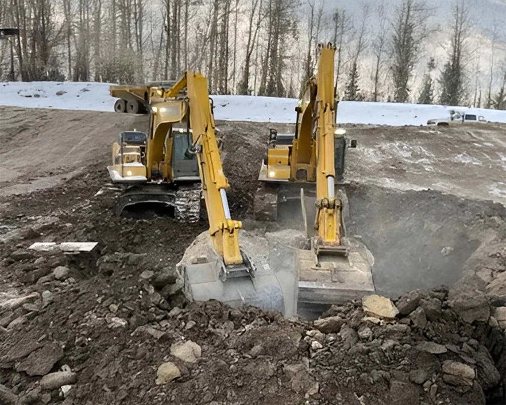 Two excavators working on an oilfield site in winter